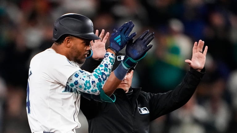 Seattle Mariners' Julio Rodríguez reacts to hitting a double against...