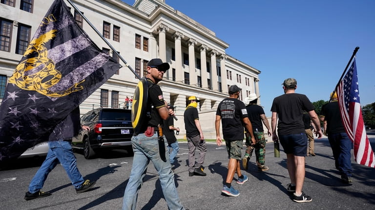 Members of the Proud Boys walk around the State Capitol...