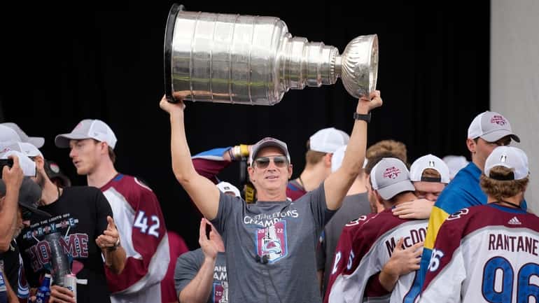 Colorado Avalanche general manager Joe Sakic lifts the Stanley Cup...