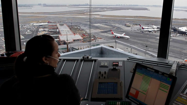 An air traffic controller works in the tower at Kennedy...