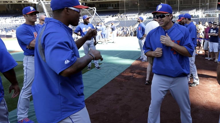Mets catcher Travis d'Arnaud, right, jokes with teammate right fielder...