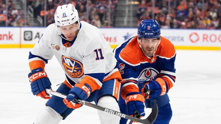 The Islanders' Zach Parise and the Oilers' Evan Bouchard battle for the...