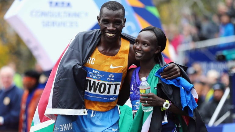 Stanley Biwott, of Kenya, men's division winner, left, poses with...