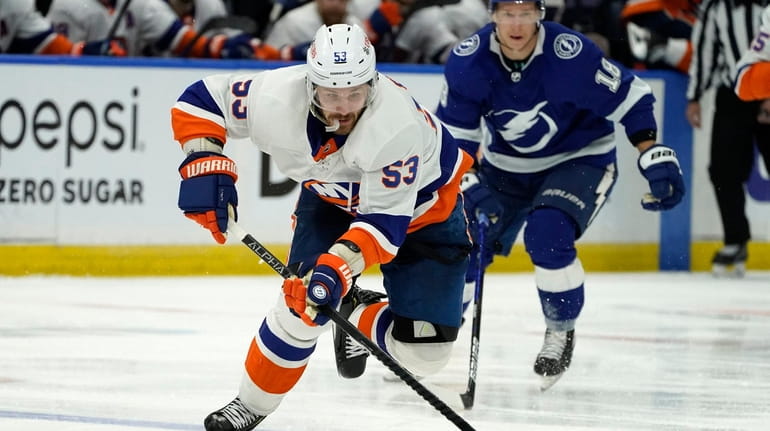New York Islanders center Casey Cizikas moves the puck as...