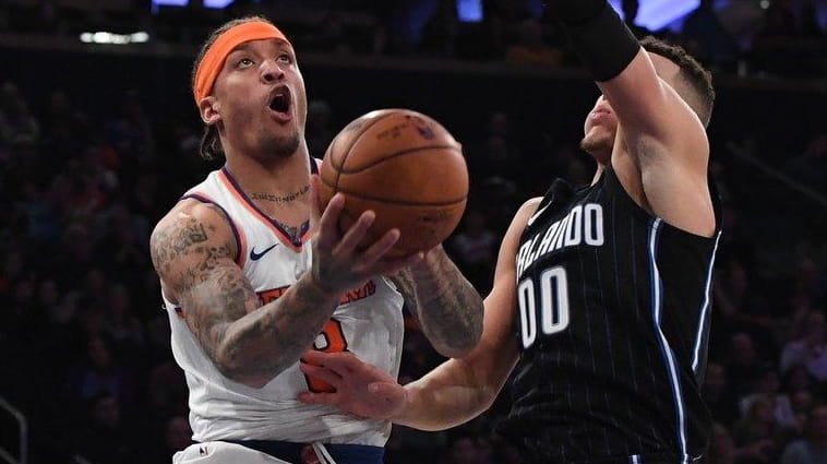 Knicks forward Michael Beasley is defended under the basket by...