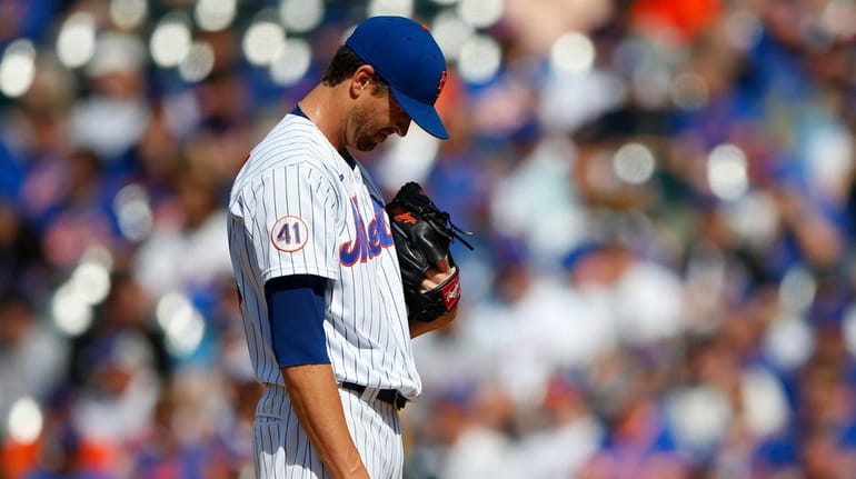 Mets starter Jacob deGrom pauses before pitching against the Phillies...