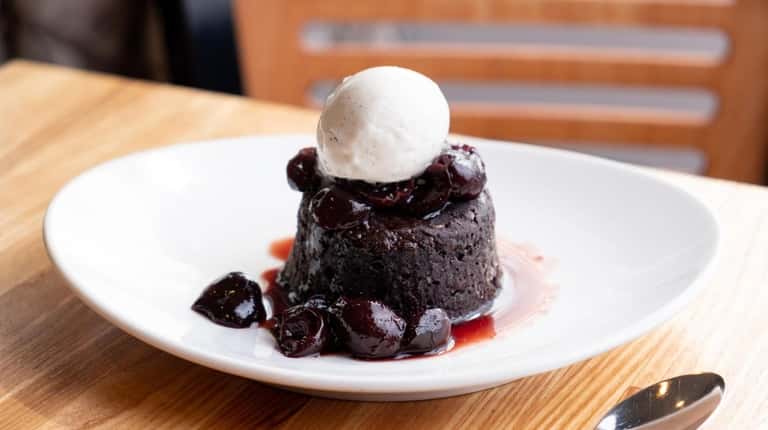 Warm chocolate cake with cherry balsamic sauce and vanilla gelato at...