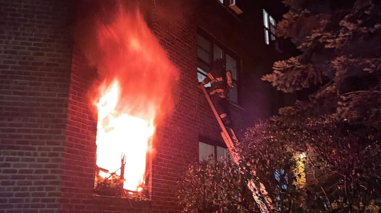 Firefighters respond to a fire in an apartment building in...