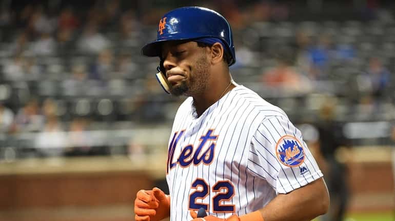 Mets' Dominic Smith returns to the dugout after he pops...