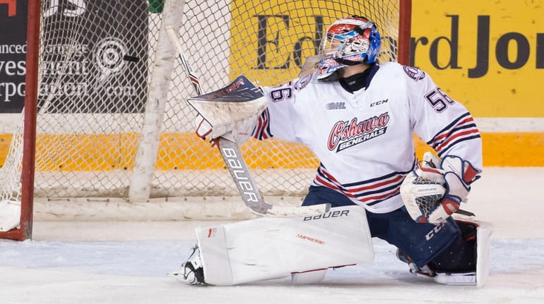 Jeremy Brodeur (56) of the Oshawa Generals watches a shot...