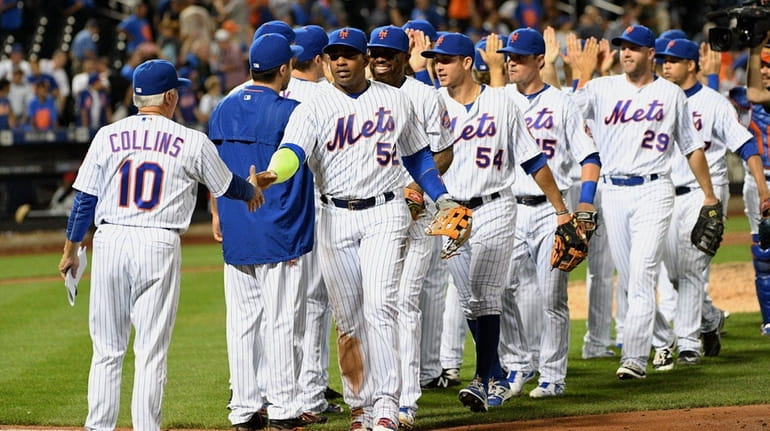 New York Mets manager Terry Collins congratulates Yoenis Cespedes and...