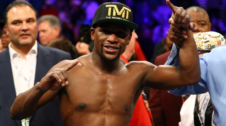 Floyd Mayweather Jr. celebrates his unanimous decision victory against Robert...