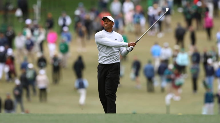 Tiger Woods watches his second shot on the first hole...