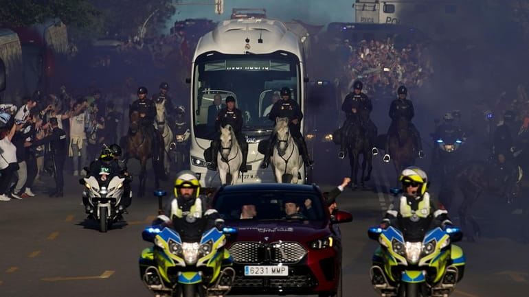 Police officers escort the bus carrying the Real Madrid players...