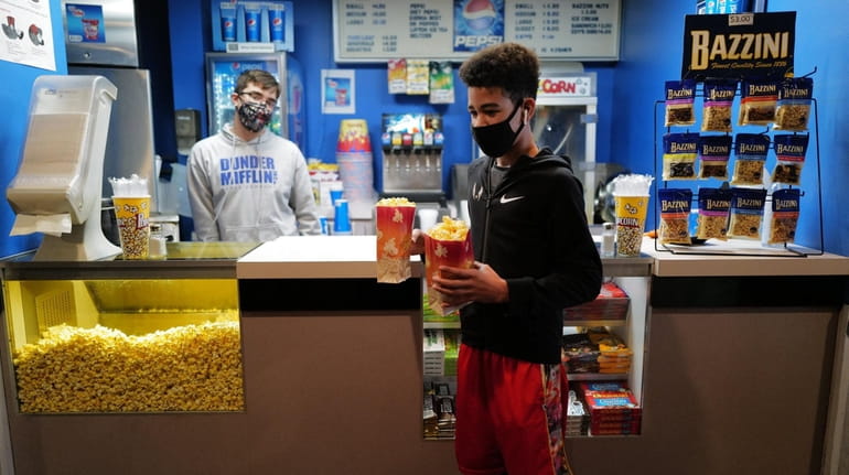 Jace Richards, 12, of Malverne, right, gets popcorn at the...