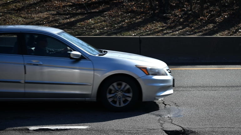 Cars drive past a pothole on the westbound Northern State...