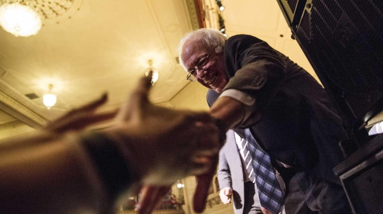 Democratic presidential candidate Sen. Bernie Sanders shakes hands with supporters...