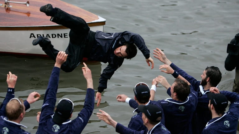 Members of the Oxford University rowing team throw their cox...