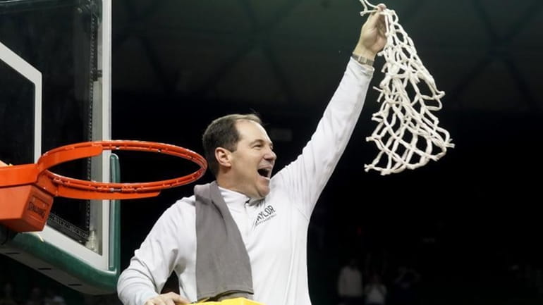 Baylor head coach Scott Drew holds up the game net...