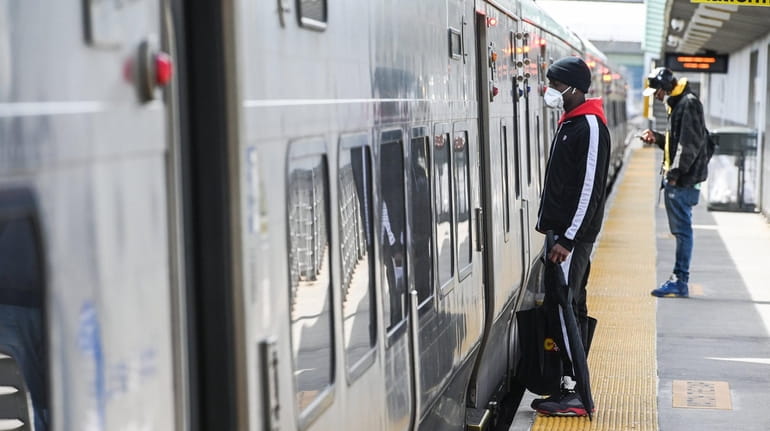 A commuter prepares to board a train at the Ronkonkoma LIRR...