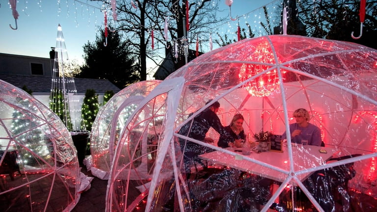 Kristen Hopkins and Nolan Tordy, dine in the outdoor igloos,...