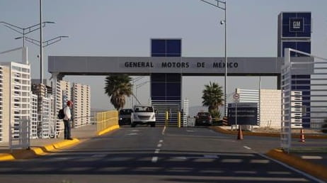 Cars leave the General Motors assembly plant in Villa de...
