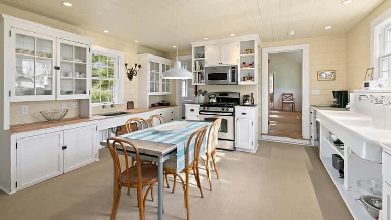 The kitchen retains vintage details, such as cabinetry, hardware and...
