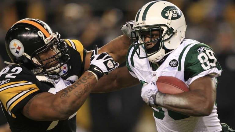 New York Jets wide receiver Jerricho Cotchery (89) fights off...