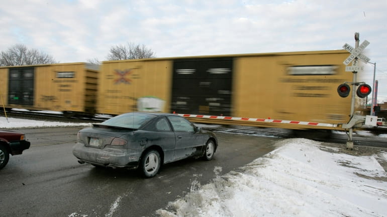 Cars wait for a train to pass, in Valley, Neb.,...