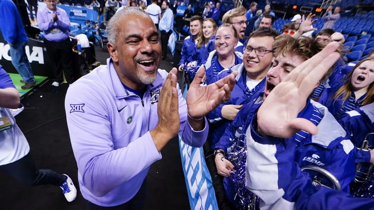 Kansas State head coach Jerome Tang celebrates with members of...