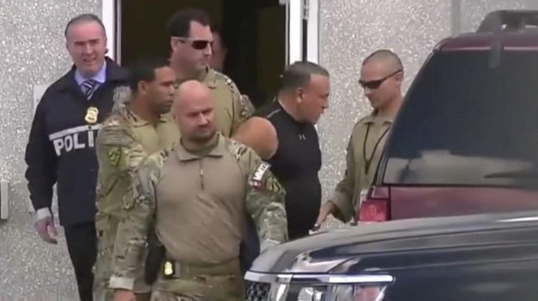 A still image from video of Cesar Sayoc being moved...