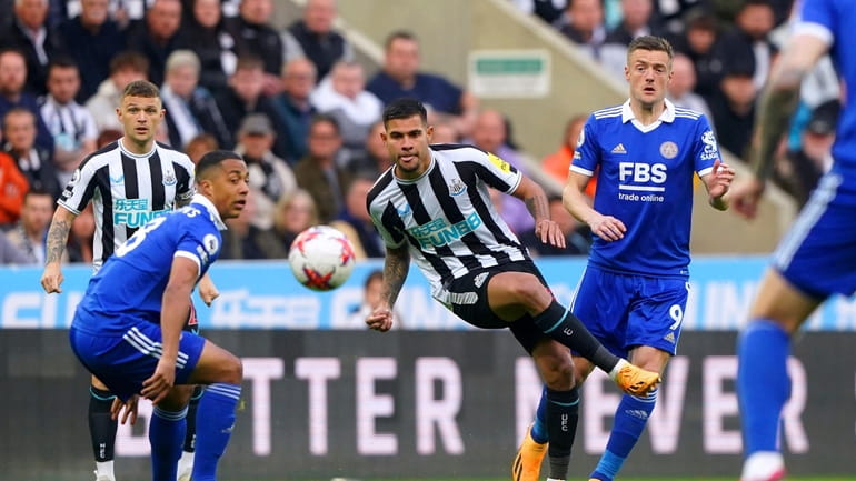Newcastle's Bruno Guimaraes, center, battles for the ball with Leicester's...
