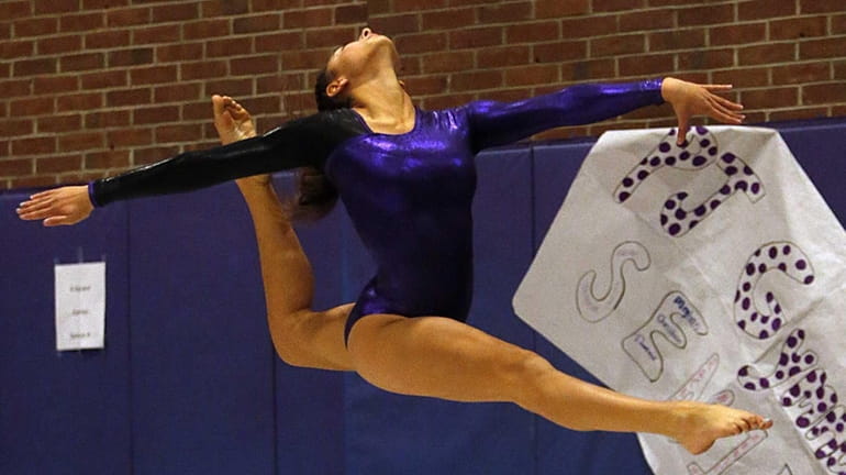 Port Jefferson's Deanna Eichinger leaps high during her floor exercise...