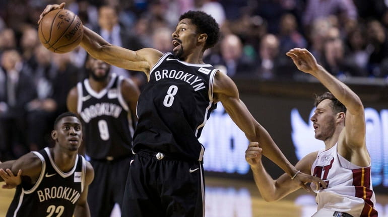 The Nets' Spencer Dinwiddie jumps for the ball next to...