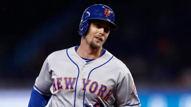 The Mets' Jeff McNeil rounds third base after hitting a solo...