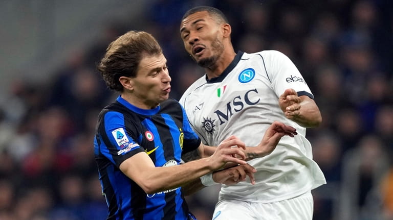Inter Milan's Nicolo Barella jumps for the ball with Napoli's...
