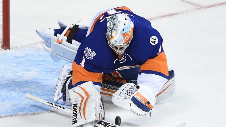 New York Islanders goalie Thomas Greiss makes a save against...