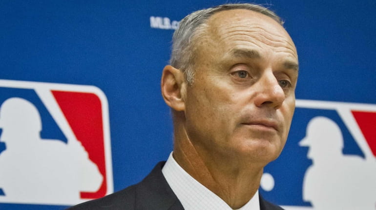 Baseball commissioner Rob Manfred listens during a press conference after...