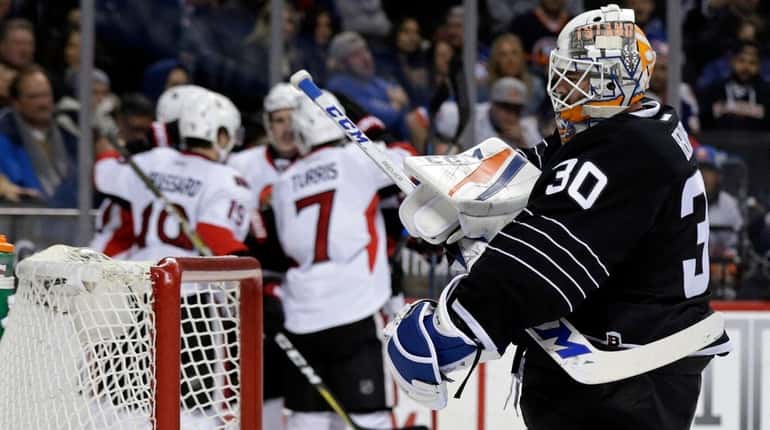 New York Islanders goalie Jean-Francois Berube reacts after giving up...