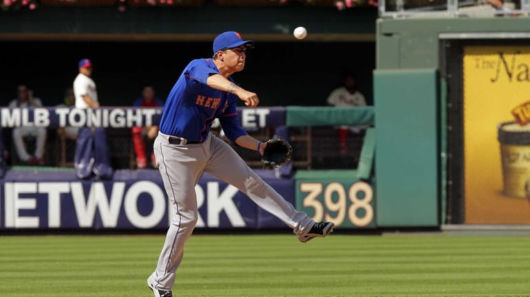 Wilmer Flores throws to first base after fielding a ground...
