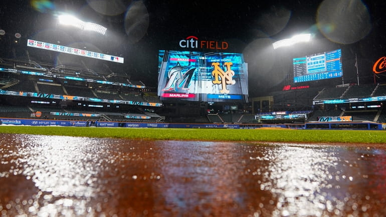 Rain falls during a rain delay in a game between...
