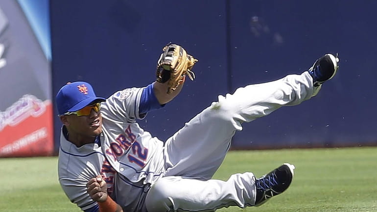 Juan Lagares gets to his feet after making a catch...