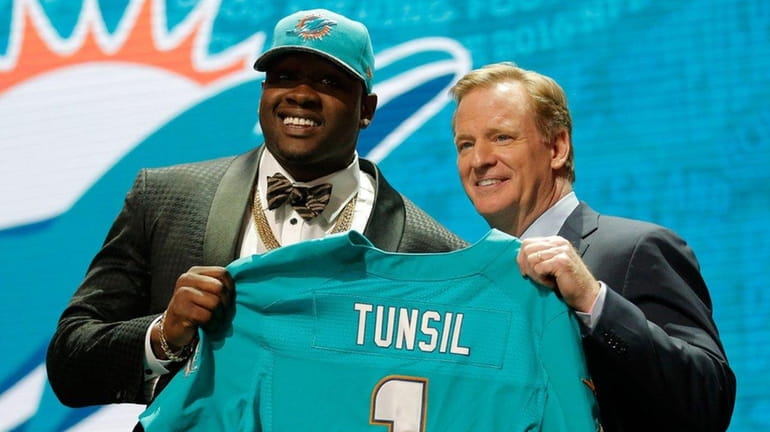 Laremy Tunsil of Ole Miss holds up a jersey with...