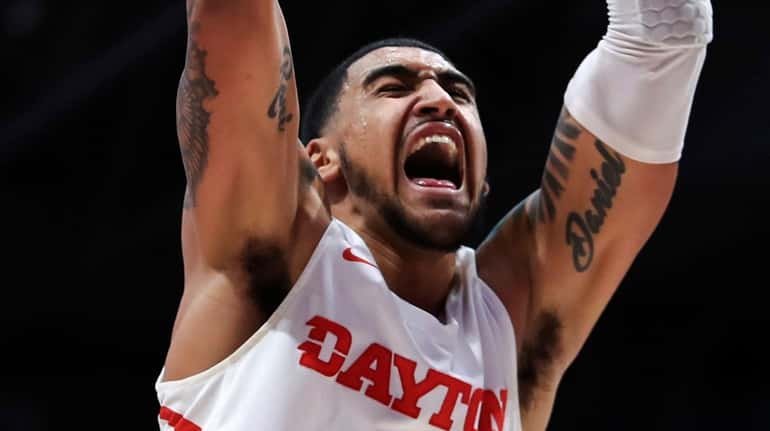 Dayton's Obi Toppin reacts as he dunks the ball in the...