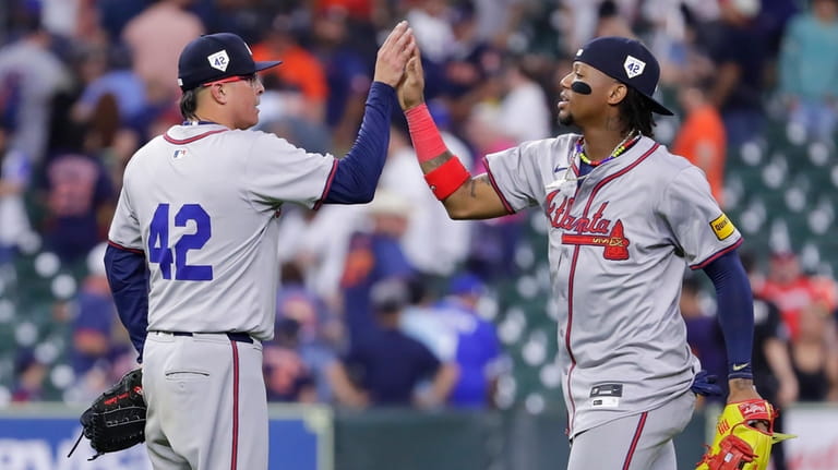 Atlanta Braves closing pitcher Jesse Chavez, left, high-fives right fielder...