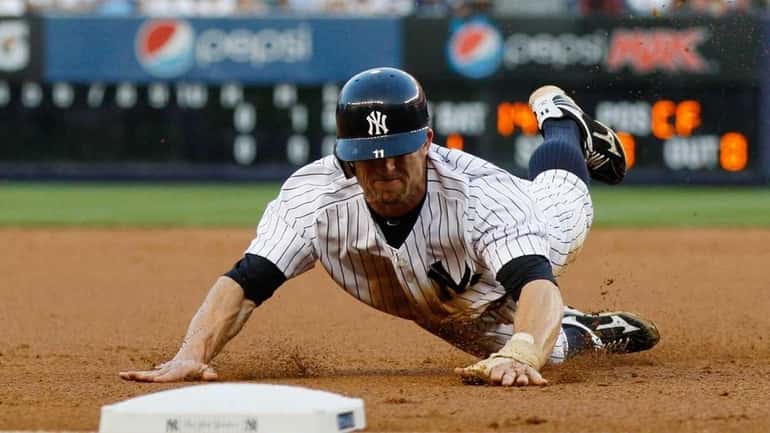 Brett Gardner #11 of the New York Yankees slides in...