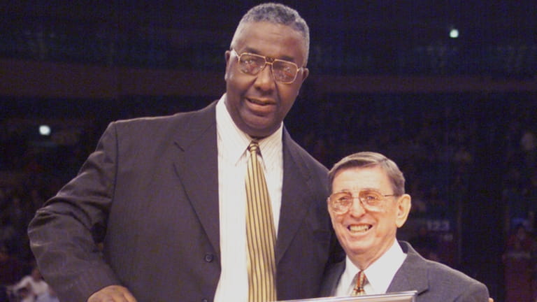John Thompson is presented with a sweater by Lou Carnesecca...