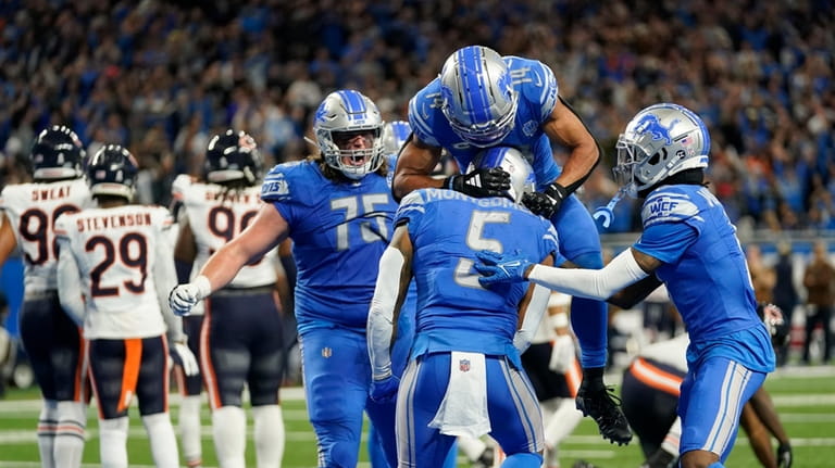 Detroit Lions wide receiver Amon-Ra St. Brown (14) jumps on...