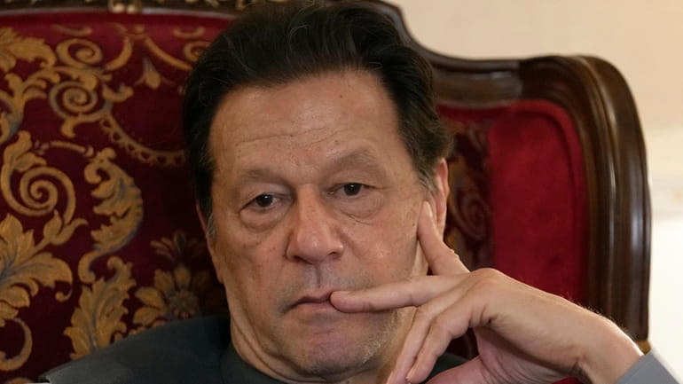 Pakistan's former Prime Minister Imran Khan listens to a member...