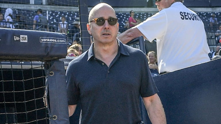 Yankees general manager Brian Cashman takes the field during spring...